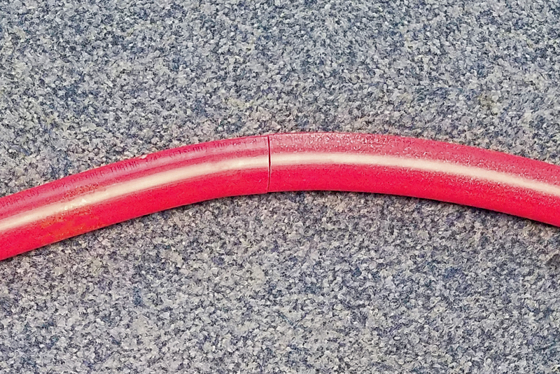 Image of red pipe with a crack in it on a counter top
