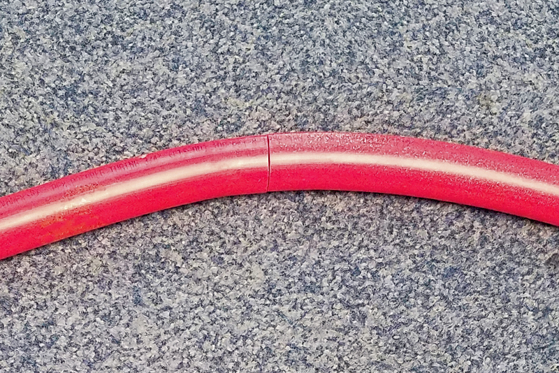 Image of red pipe with a crack in it on a counter top