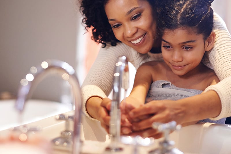 Mom and Daughter washing hands together at the bathroom sink