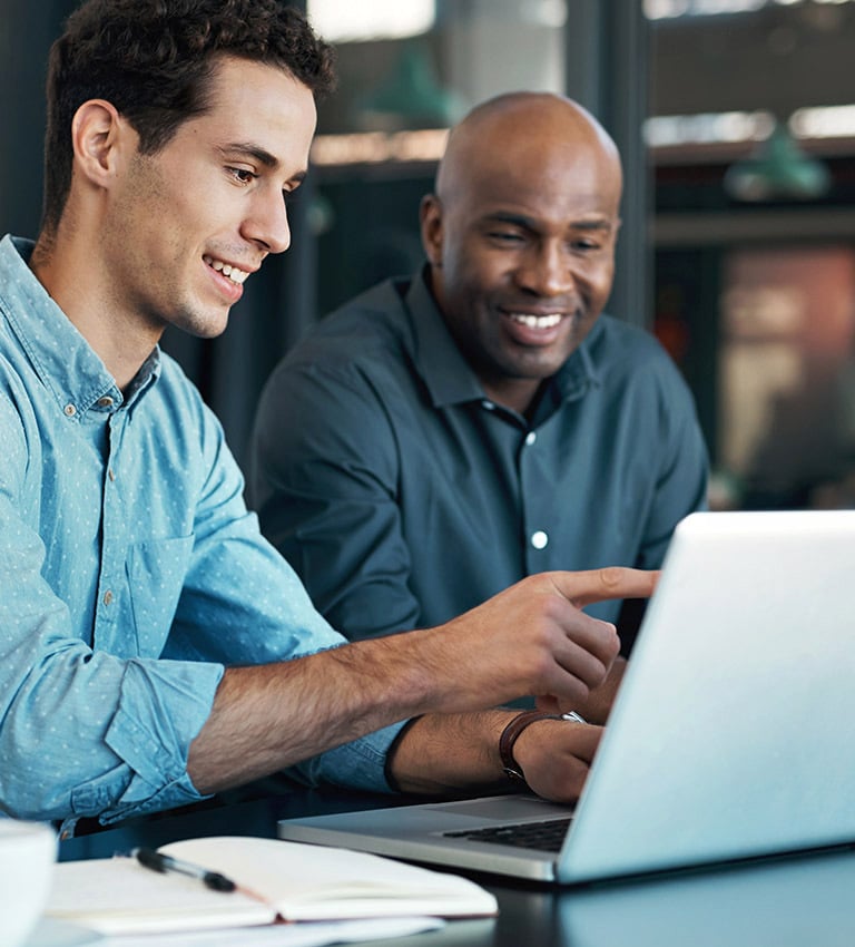 Two men reviewing work plans on a laptop